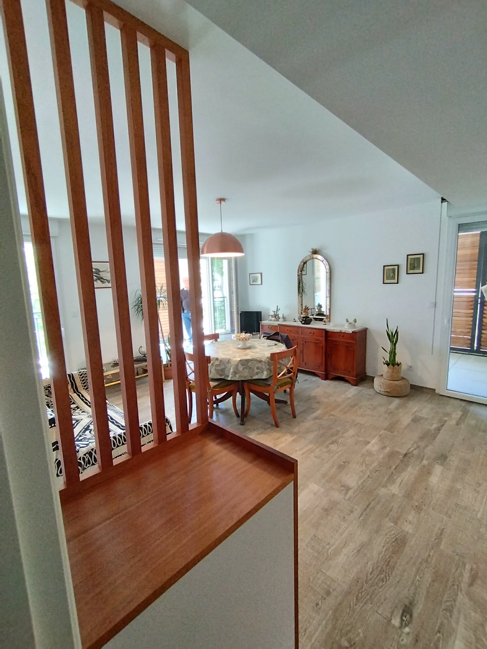 Banquette en bois intégrée à une cloison ajourée de lames verticales