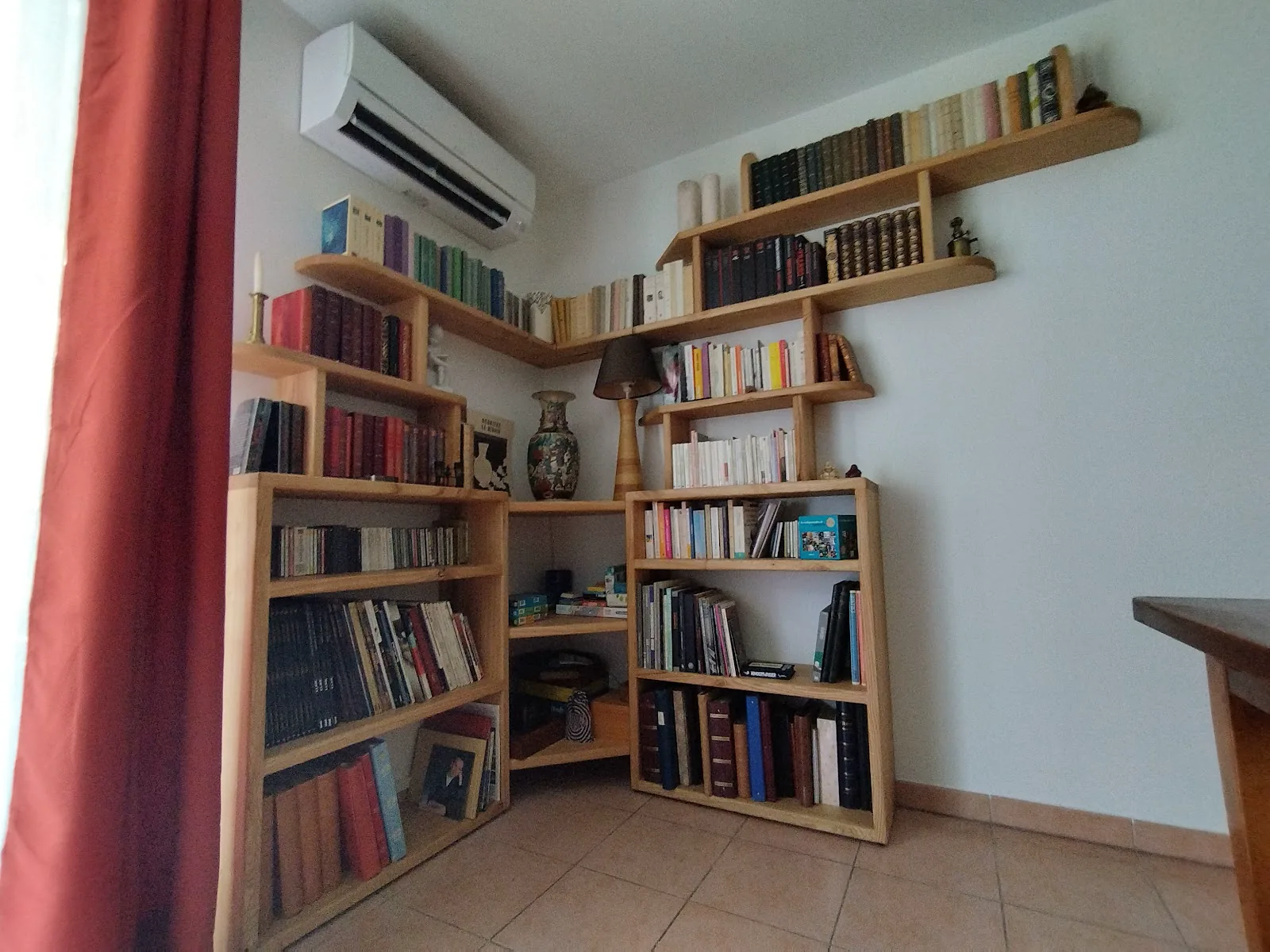 Bibliothèque en bois aménagée dans un angle de pièce