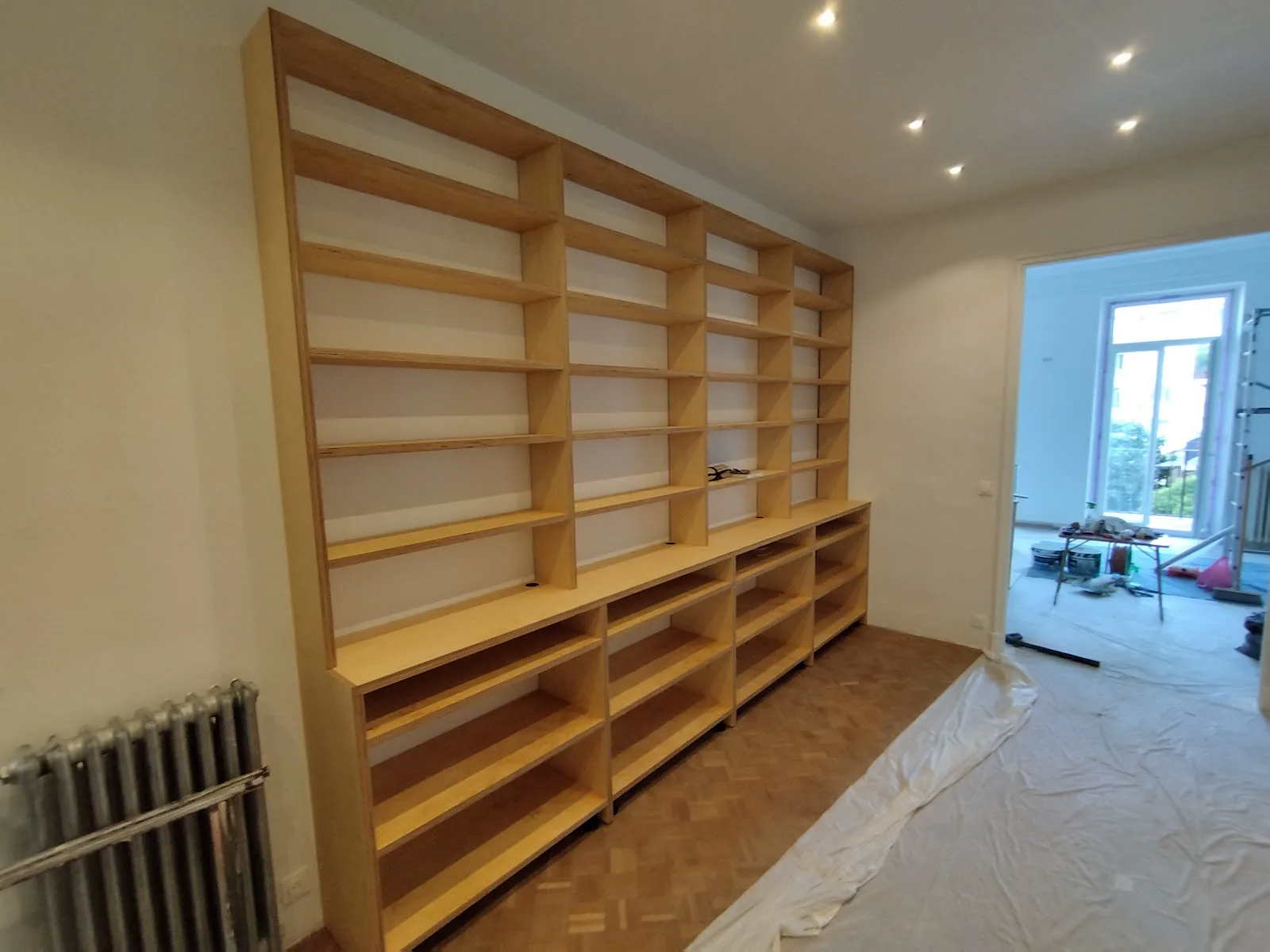 Bibliothèque et rangements bas en bois dans une pièce lumineuse